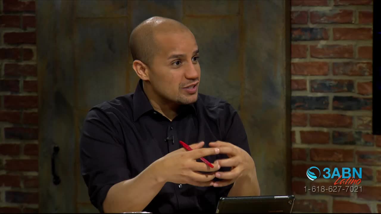 A man in a black shirt gestures with both hands, a red pen held between his fingers. The 3ABN Latino logo is visible in the corner of the frame.
