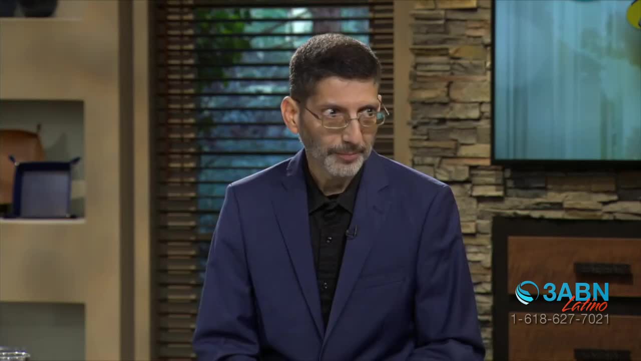 A man in a blue suit and glasses looks off to the side, a slight smile playing on his lips. The 3ABN Latino logo sits in the corner of the screen.
