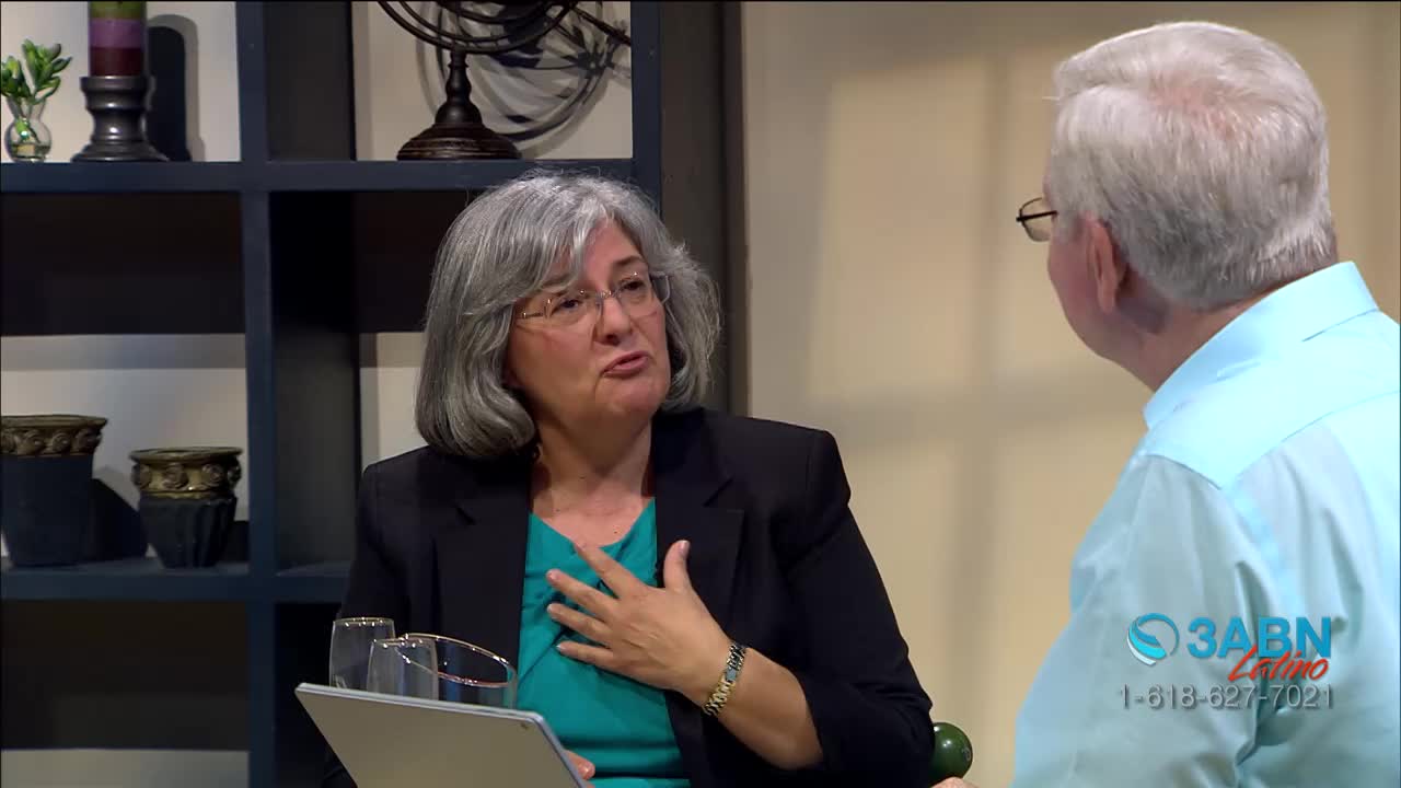 A woman in a blazer gestures with her hand over her chest as she speaks. The man in a light blue shirt listens intently, facing away from the camera; the 3ABN Latino logo is visible in the corner.
