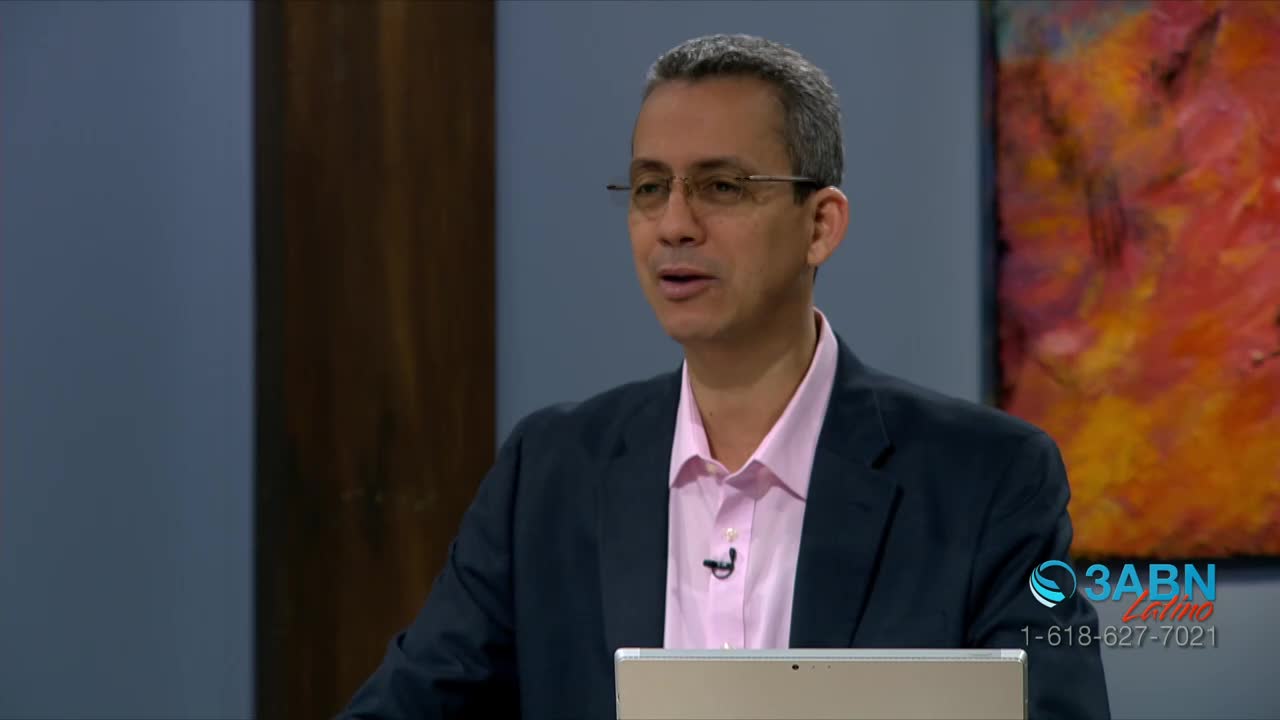 A man in a pink shirt and a navy blazer is speaking, his mouth open as he looks towards the camera. A 3ABN Latino logo is visible in the corner, along with a phone number.
