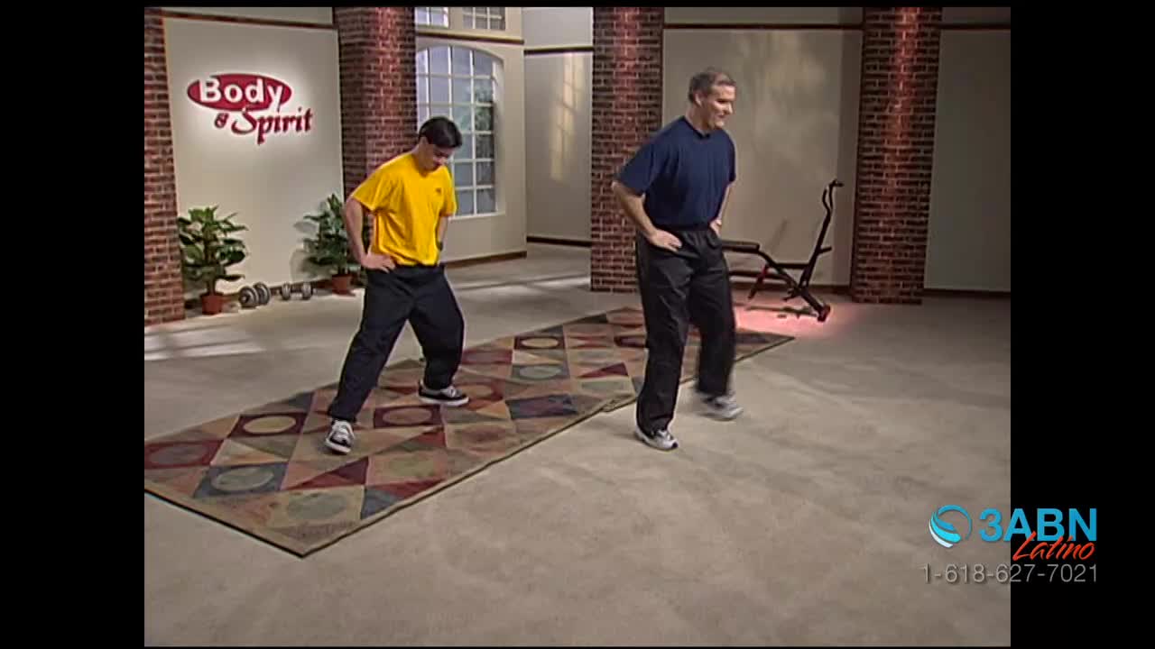Two men in exercise clothes are stepping from side to side on a patterned rug, hands on their hips. The 3ABN Latino logo is visible in the corner.
