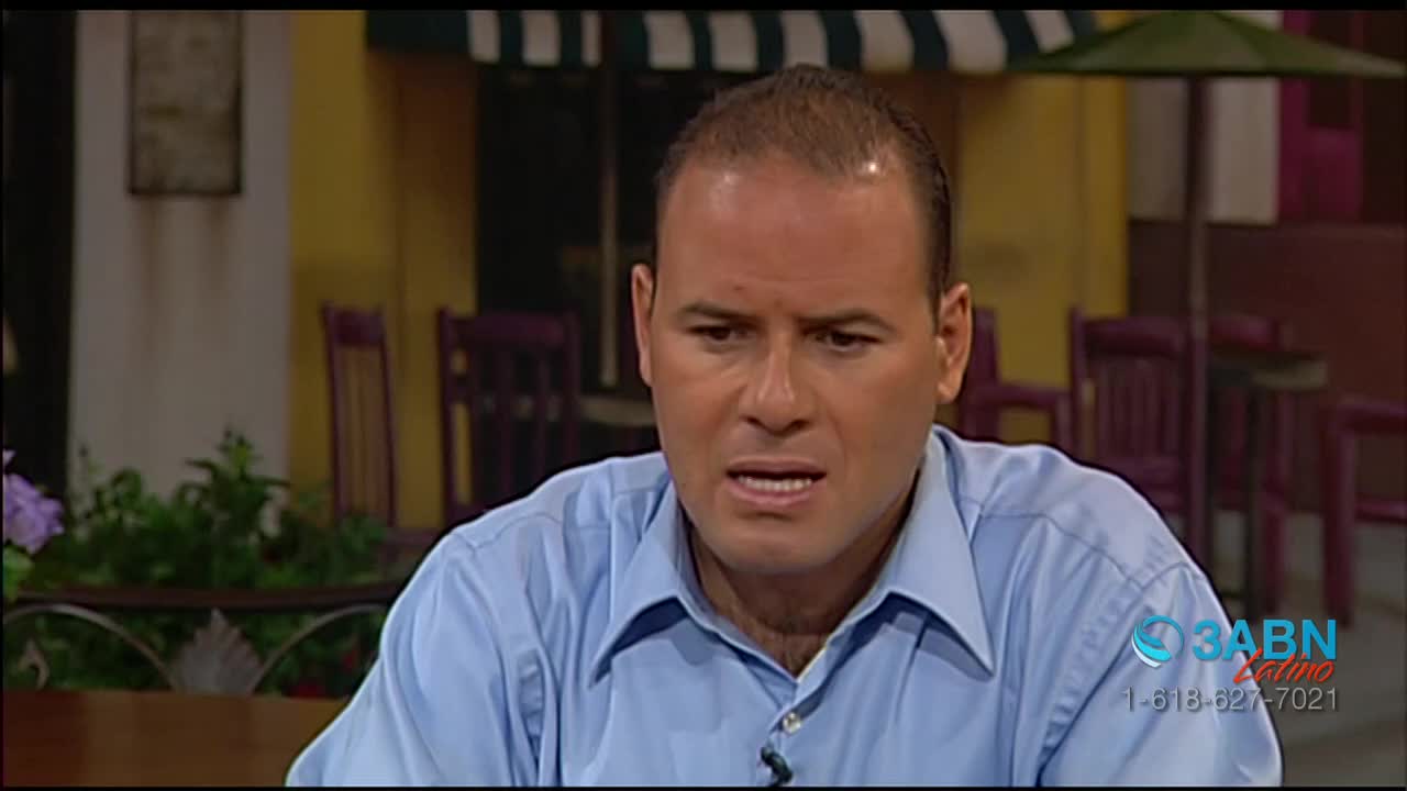 A man in a blue button-down shirt is speaking, his expression a mix of concern and intensity. The 3ABN Latino logo is visible in the corner, and the backdrop suggests an outdoor cafe setting.
