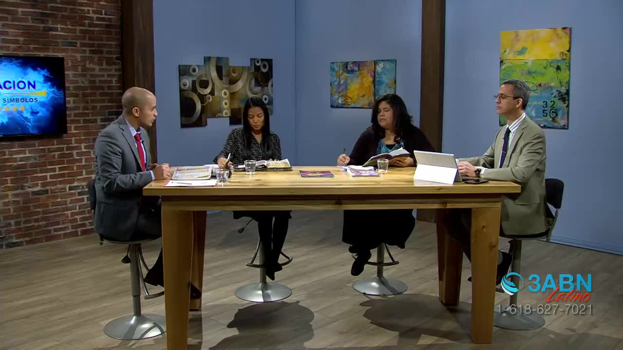Four people sit around a wooden table, each with a pen and paper, engaged in conversation. The 3ABN Latino logo is visible in the corner, and a screen displays a title in Spanish.
