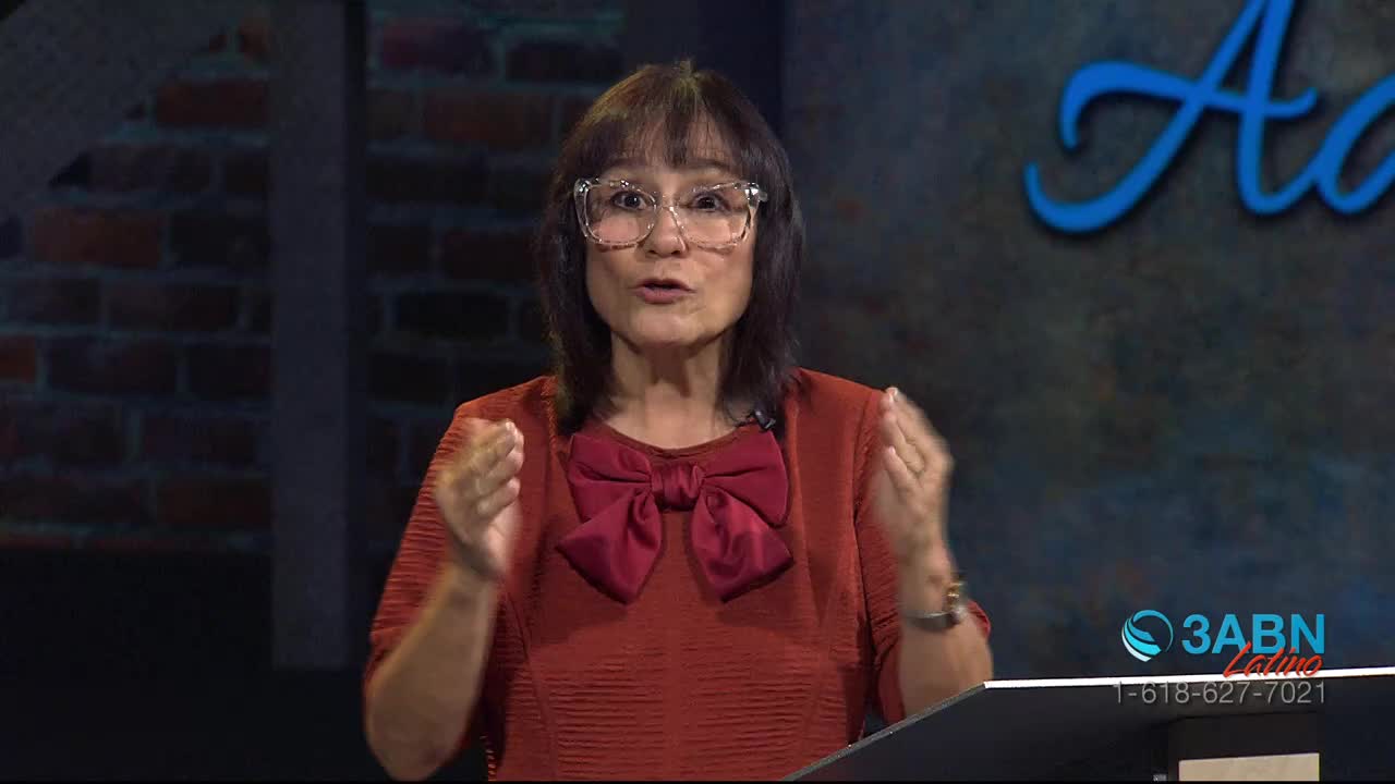 A woman with glasses and a red bow is speaking, her hands gesturing outwards. The 3ABN Latino logo is visible in the corner.
