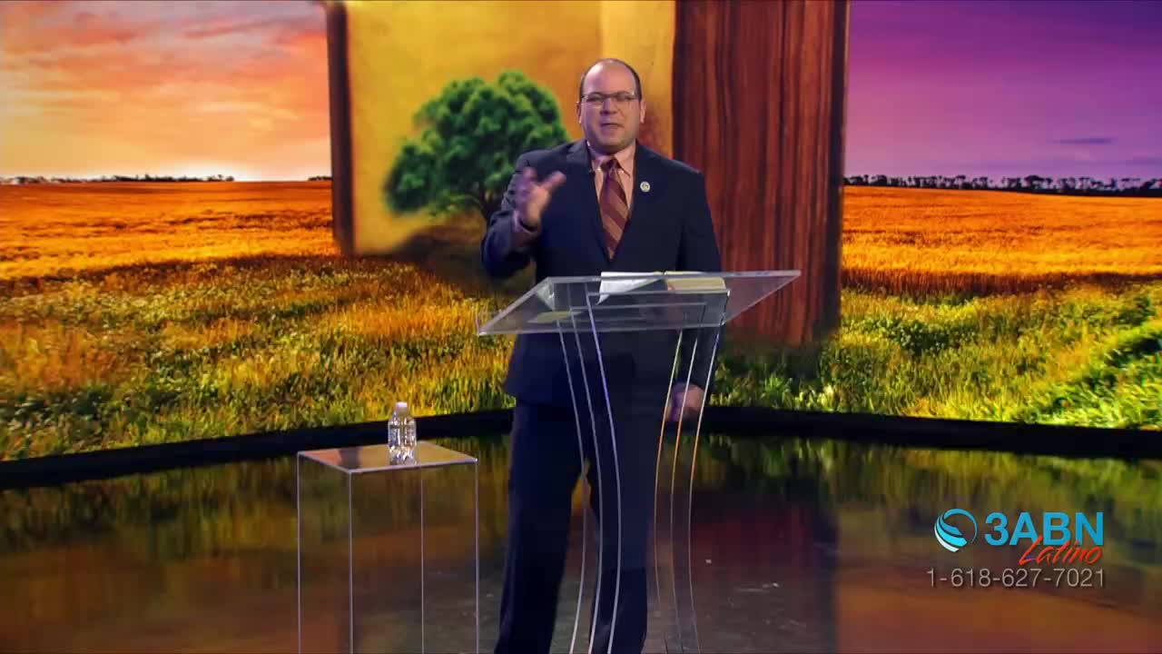 A man in a suit gestures with his hands at a transparent podium, speaking to the camera. Behind him, a pastoral landscape fills the screen, and the 3ABN Latino logo is visible in the corner.
