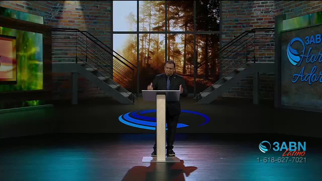 A man in a suit stands behind a podium, gesturing with his hands as he speaks. The 3ABN Latino logo is visible in the lower right corner of the studio set.
