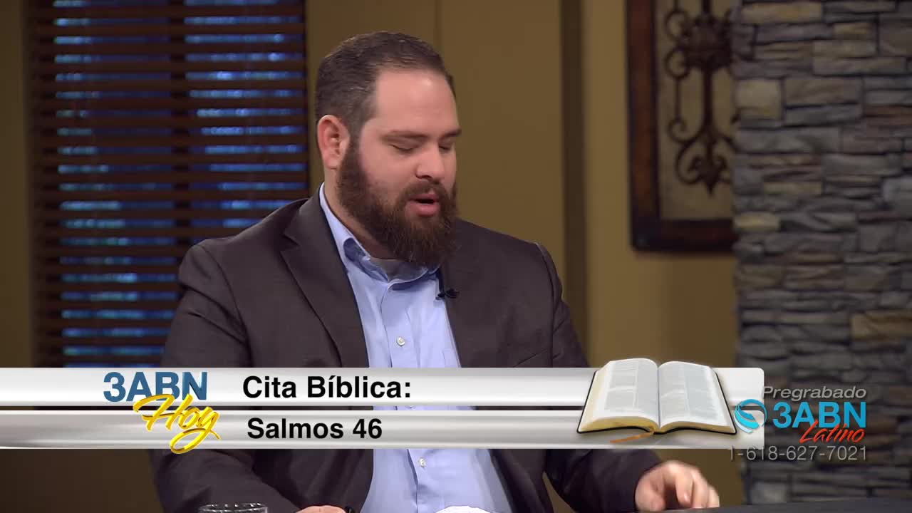 A man with a beard, wearing a suit jacket over a blue collared shirt, speaks into a microphone. A graphic displays "3ABN Hoy Cita Bíblica: Salmos 46" and an open Bible.