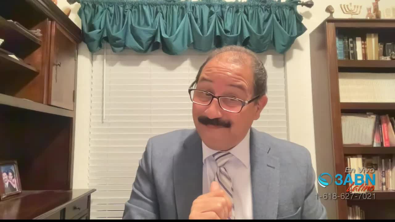 A man in a suit and tie gestures with his right hand while speaking. A logo for 3ABN Latino appears in the lower right corner.