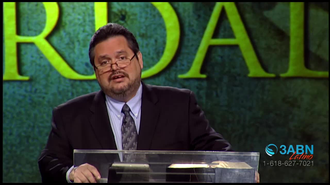 A man in a suit stands behind a clear lectern, speaking to the camera. A logo for 3ABN Latino is visible in the lower right corner.