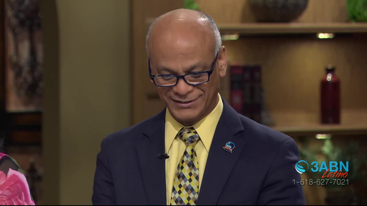 A man in a suit and tie smiles as he looks down. The 3ABN Latino logo appears in the corner of the screen.