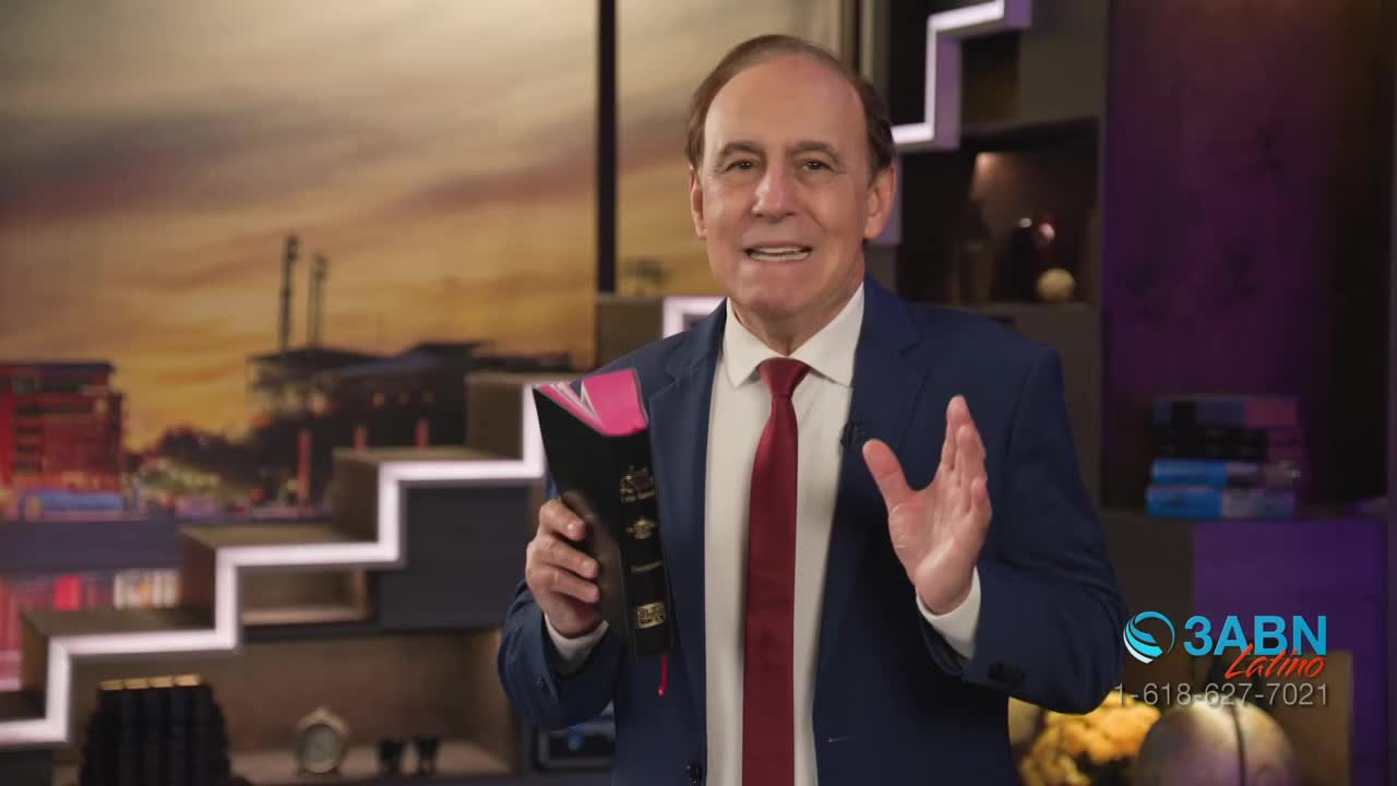 A man in a suit gestures with his right hand while holding a Bible in his left. He speaks with a backdrop of a city skyline at sunset.