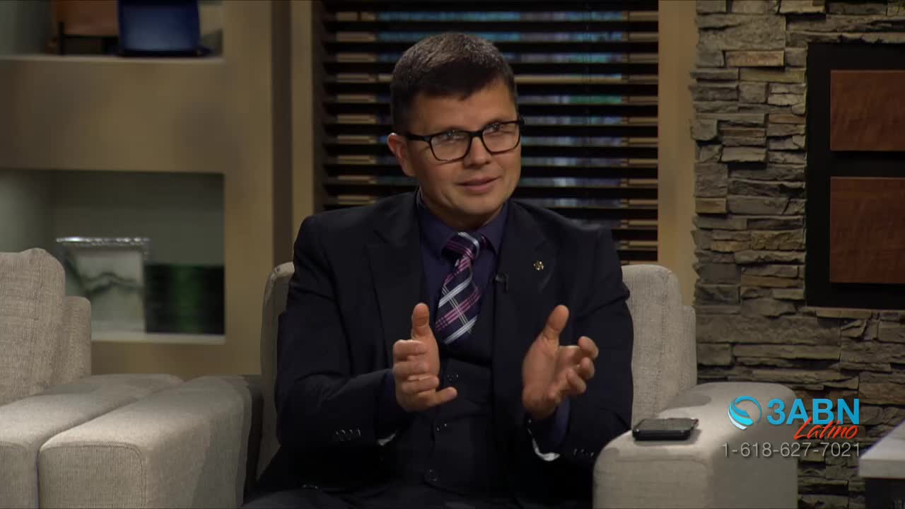 A man in a suit and tie gestures with his hands while speaking. A logo for 3ABN Latino and a phone number are visible on the right.