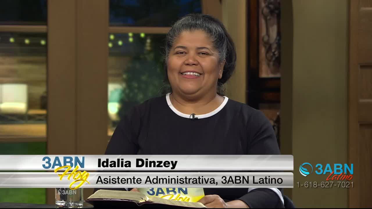 Idalia Dinzey smiles warmly, her dark hair pulled back. She's wearing a black shirt with a white collar, and the 3ABN Latino logo is visible.