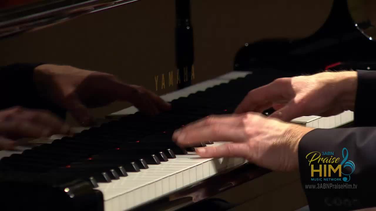 Fingers dance across the piano keys, a Yamaha, reflecting in the glossy black surface. The music is for 3ABN Praise Him Music Network, likely filmed in the United States.
