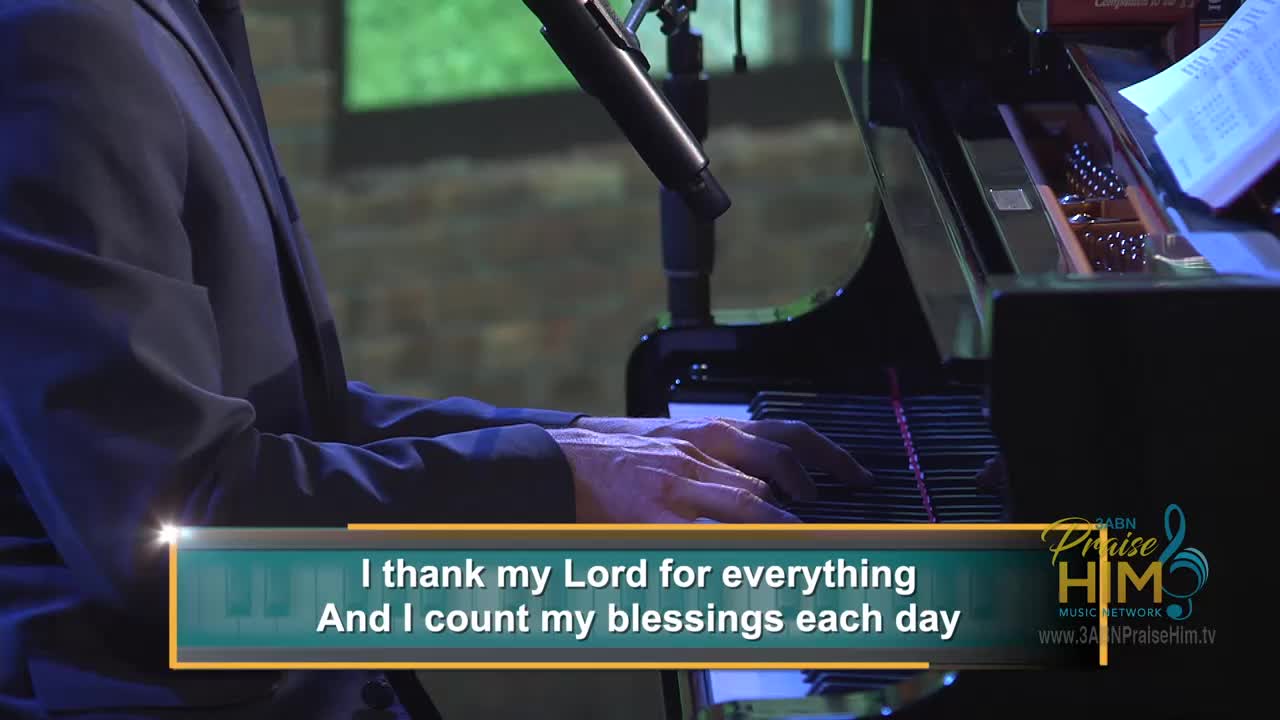 A man in a dark suit plays the piano, his hands moving over the keys. The words "I thank my Lord for everything" are displayed on screen, with the 3ABN Praise Him Music Network logo visible in the corner.
