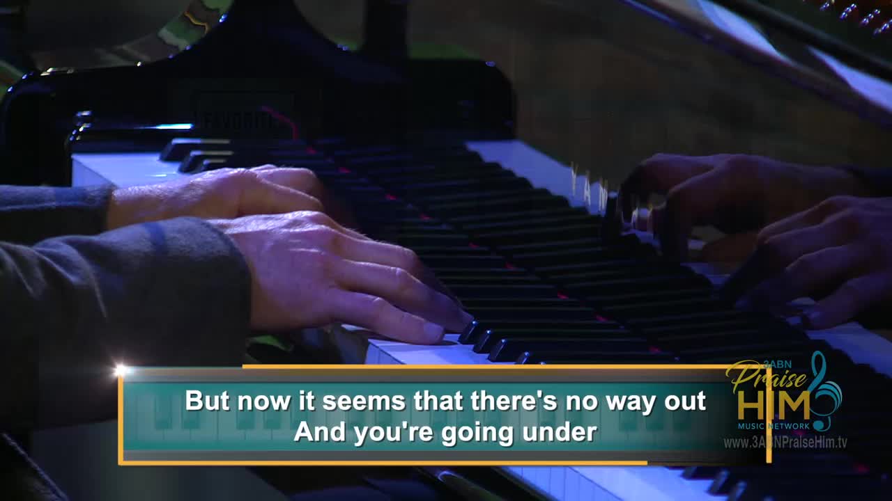 A pianist's hands dance over the keys, fingers pressing down with precision. The scene is from 3ABN Praise Him Music Network, with lyrics displayed on screen.
