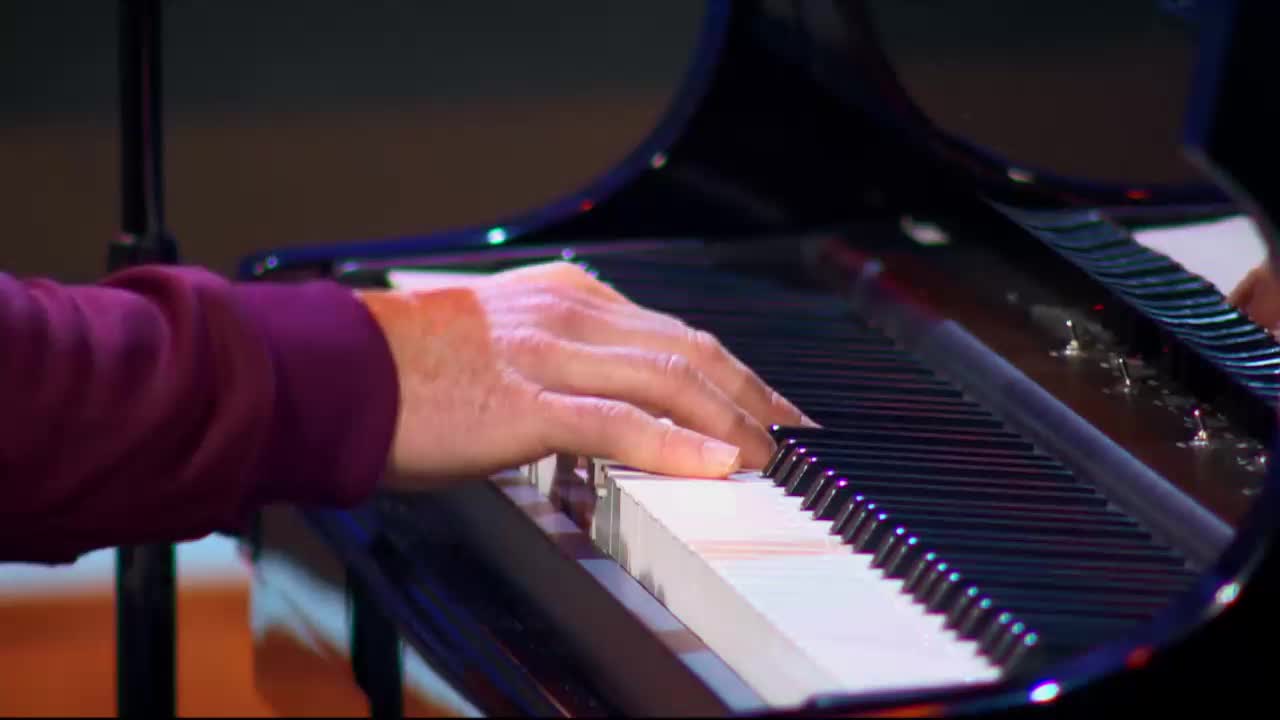 Fingers dance across the piano keys, a performance for 3ABN Praise Him Music Network. The polished black grand piano gleams under the stage lights.