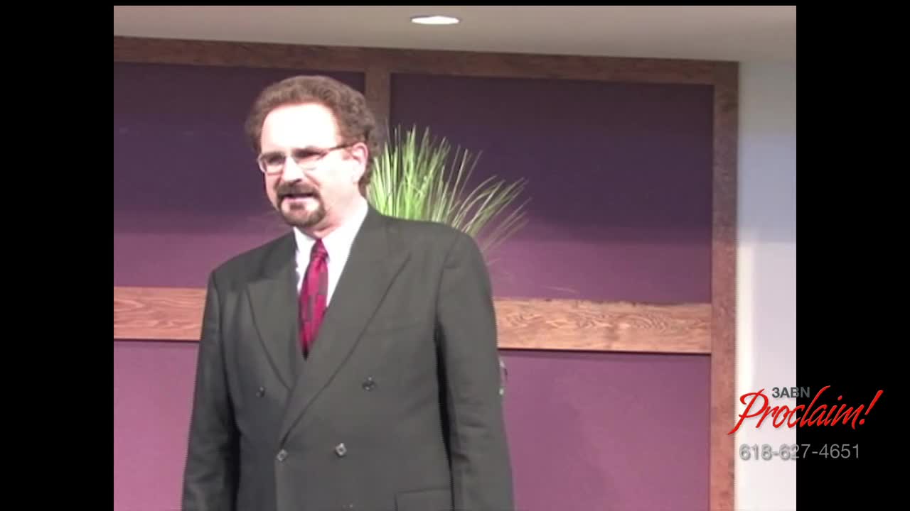A man in a dark suit and tie stands at a podium, speaking. The 3ABN Proclaim! logo is visible in the corner.
