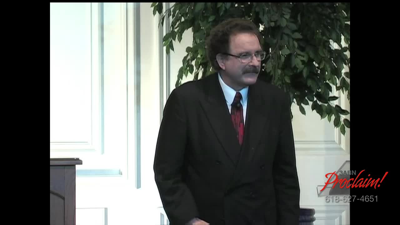 A man in a dark suit and tie stands near a podium, looking off-camera. The 3ABN Proclaim! Network logo is visible in the corner.
