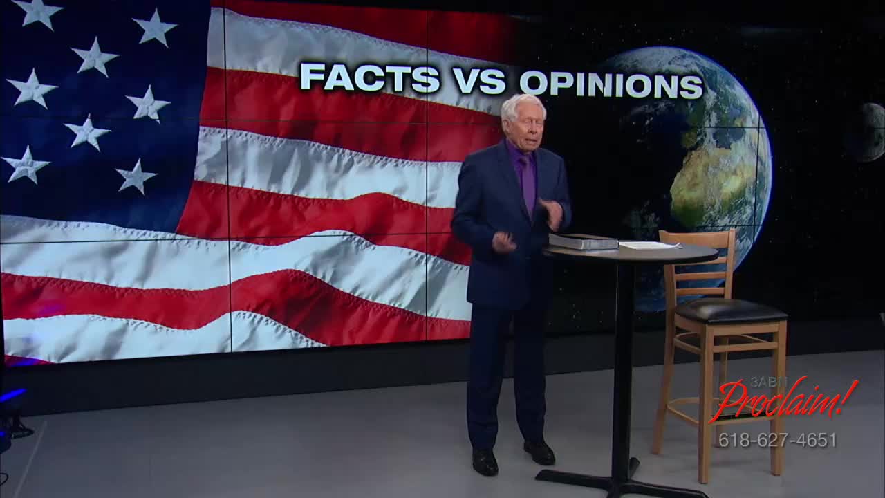 A man in a blue suit gestures as he speaks, standing in front of a backdrop featuring the United States flag and a globe. The 3ABN Proclaim! Network logo is visible in the corner.

