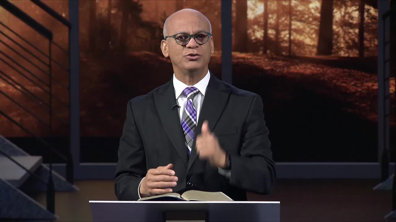 A man in a suit gestures with his hands while speaking, a book open on the podium in front of him. The broadcast is likely from the United States, on the 3ABN Proclaim! Network.
