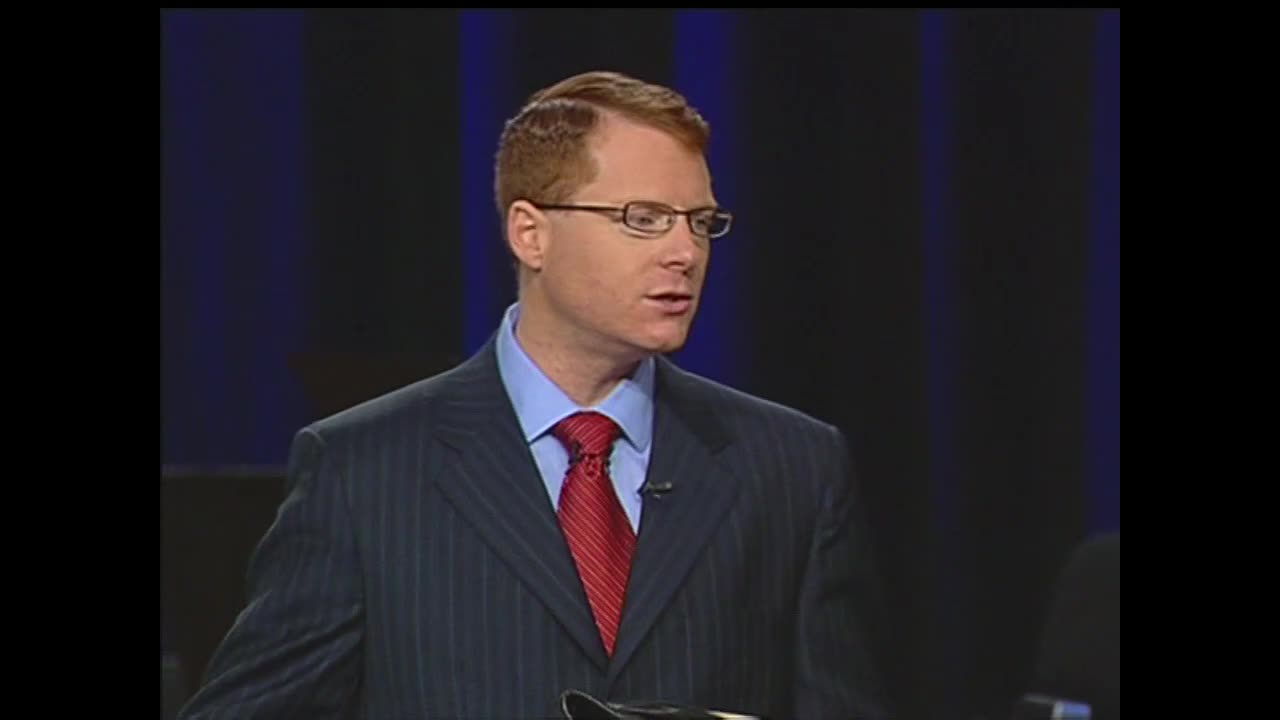 A man in a pinstripe suit and red tie speaks into a microphone, his gaze directed slightly off-camera. The backdrop is a dark blue, typical of a studio set on the 3ABN Proclaim! Network from the United States.
