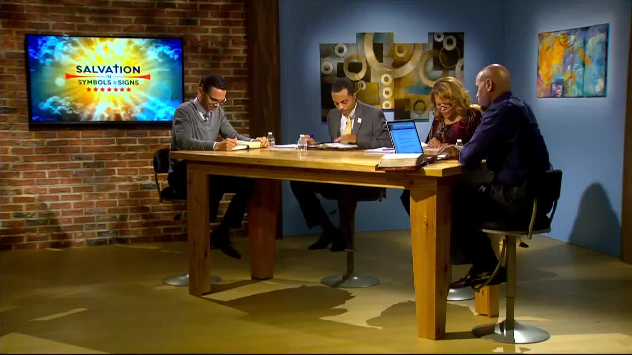 Four people sit at a wooden table, engaged in discussion. A screen behind them displays the 3ABN Proclaim! Network logo.
