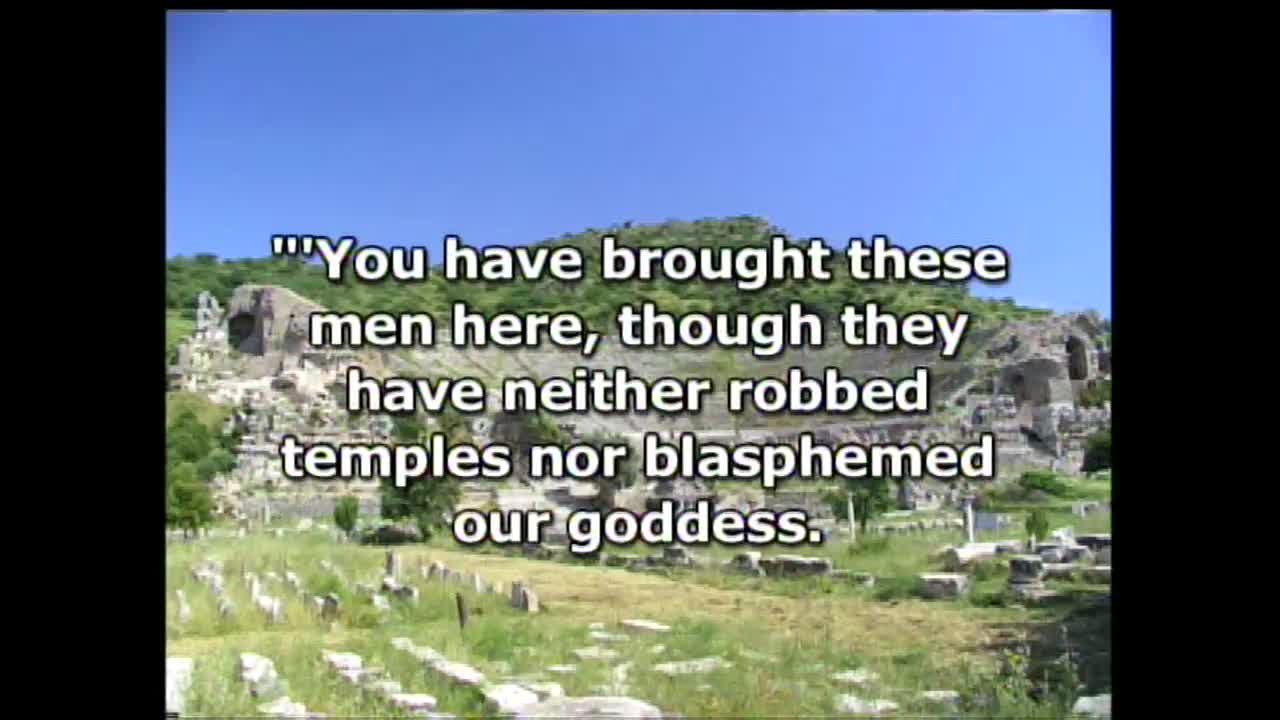 Ancient ruins stand under a bright blue sky. Text overlays the scene, quoting a statement about men brought before a goddess.