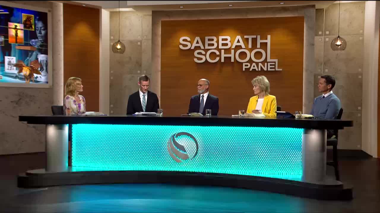 Five people are seated at a desk in front of a "Sabbath School Panel" sign. The 3ABN Proclaim! Network logo glows on the desk's front panel.