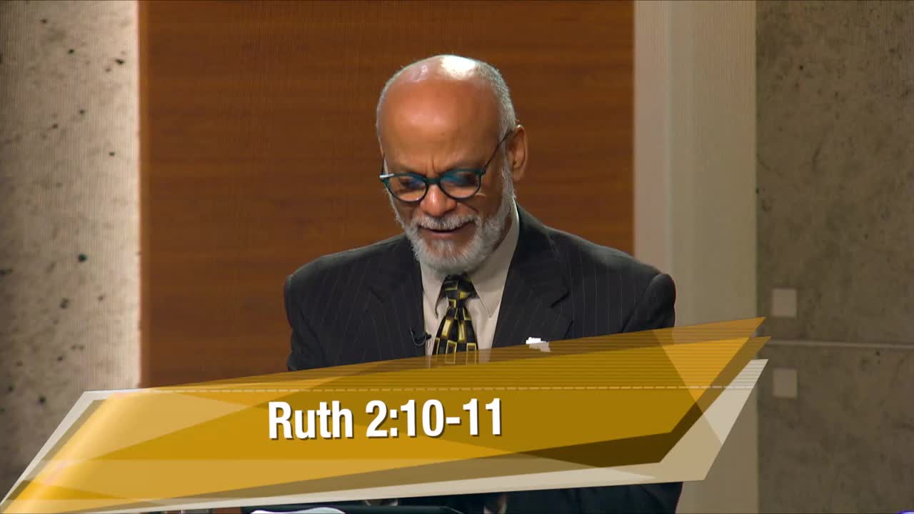 A man with a beard and glasses is speaking, looking down at a podium. A graphic overlay reads "Ruth 2:10-11."