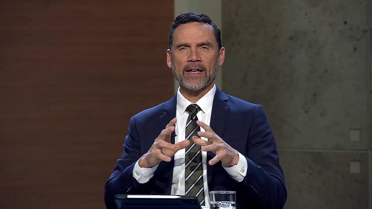 A man in a suit speaks with his hands animated, his gaze directed forward. He's on the 3ABN Proclaim! Network, a broadcast originating from the United States.