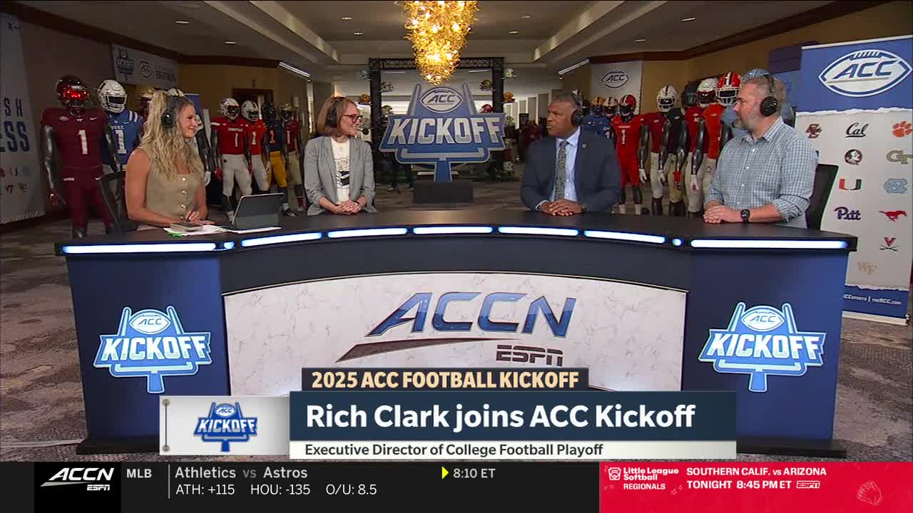 Four people in headsets sit behind a curved desk, the ACC Kickoff logo displayed prominently. Behind them, football uniforms in various team colors stand on display.
