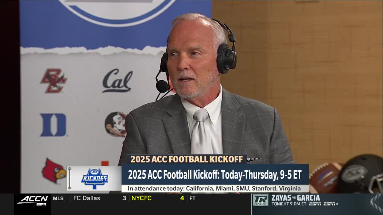 A man in a gray suit and headset speaks into a microphone. Behind him, the ACC Network logo and team logos are visible, advertising the 2025 ACC Football Kickoff.

