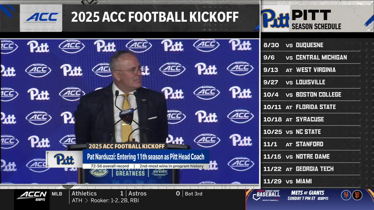 Pat Narduzzi, the Pitt head coach, stands at a podium, addressing the crowd at the 2025 ACC Football Kickoff. Behind him, a screen displays the team's schedule for the upcoming season on the ACC Network.
