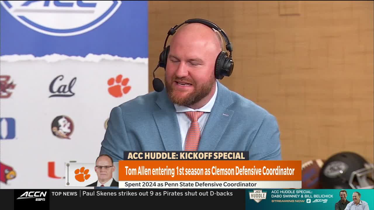 A man in a light blue blazer and headset is speaking, likely on the ACC Network's "Huddle" kickoff special. The background features logos for college football teams, including Clemson.
