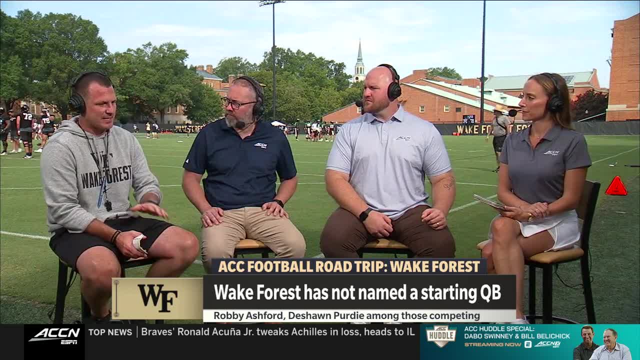 Four people wearing headsets are seated on chairs, discussing something on the Wake Forest football field. The ACC Network logo is visible, and a graphic highlights the team hasn't named a starting quarterback.
