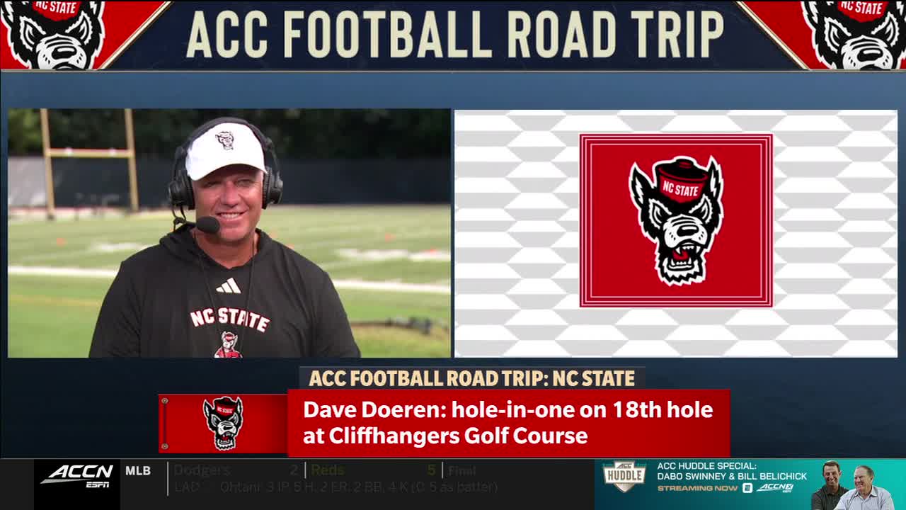 Dave Doeren, wearing an NC State cap and sweatshirt, smiles into the camera on the ACC Network. A graphic on the screen highlights his hole-in-one at Cliffhangers Golf Course.
