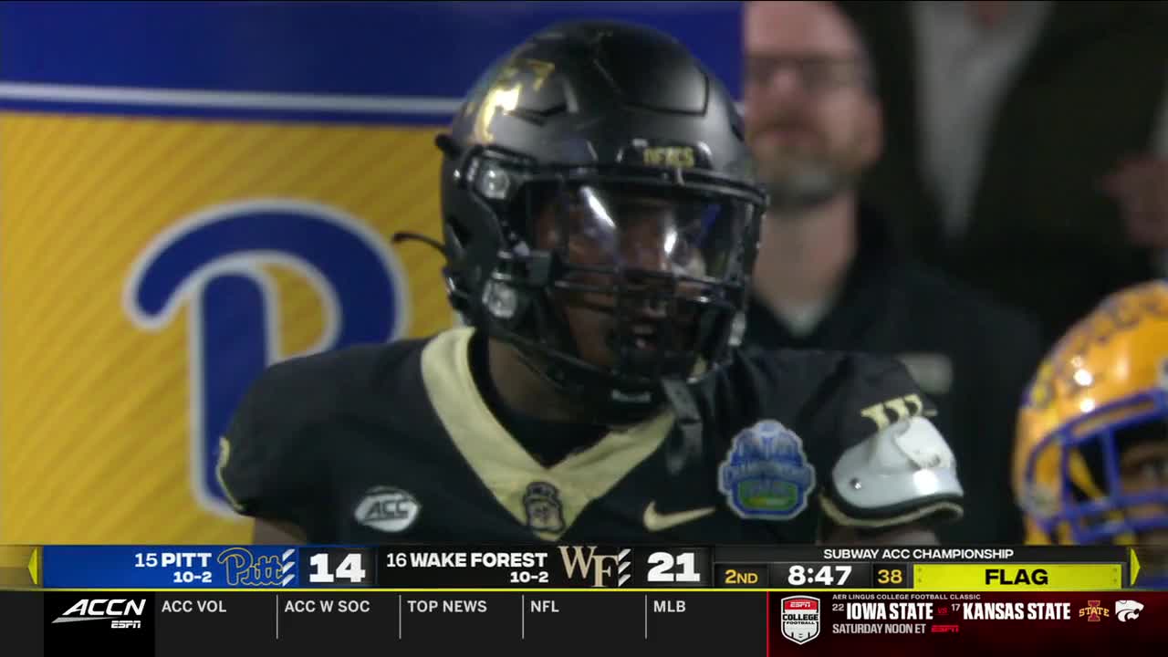 The Wake Forest player in the black helmet looks up, his face obscured by the visor. The ACC Championship game is in the second quarter, and the score is 21-14.
