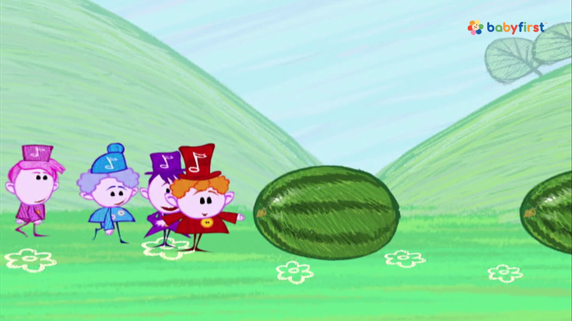 Four cartoon figures in colorful outfits are walking toward a large watermelon. A second watermelon sits further in the background, and a green hill rises behind them.
