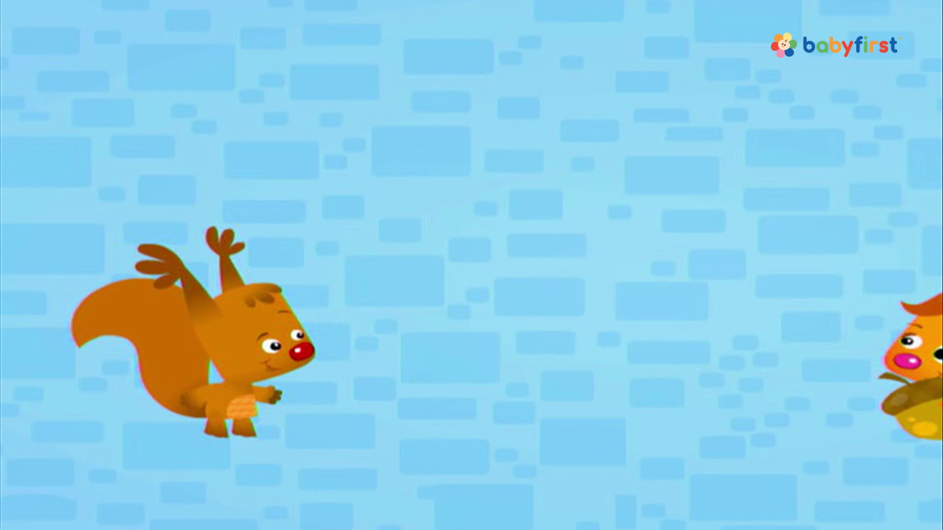 A cartoon squirrel with a large, fluffy tail is jumping with its arms raised. Another character, shaped like an acorn, is watching from the right side of the screen.
