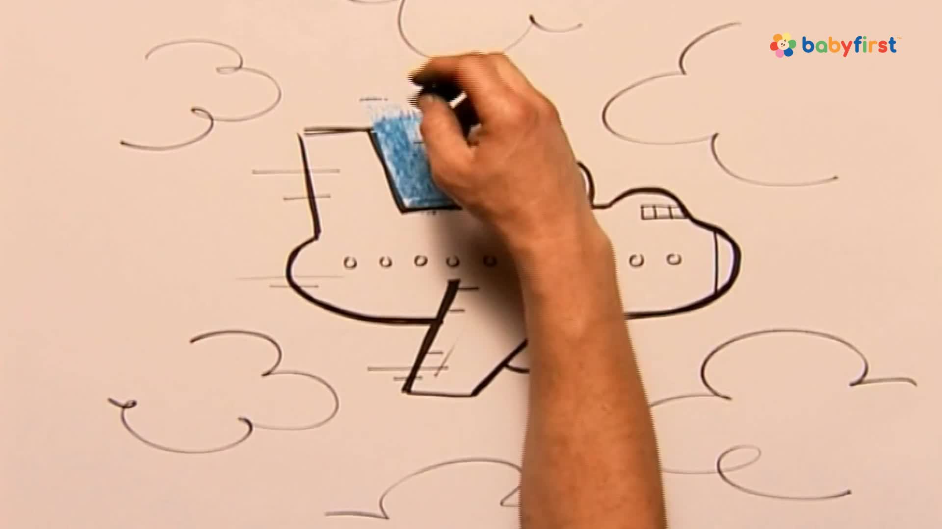 A hand is coloring the top of a drawn airplane blue. The plane is outlined in black, with speed lines and simple cloud shapes drawn around it.
