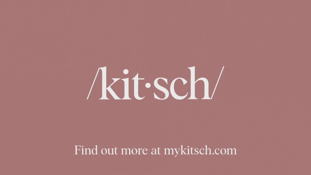 Against a muted rose background, the word "kitsch" is displayed in elegant white lettering. Below, a prompt encourages viewers to visit a website for more information.
