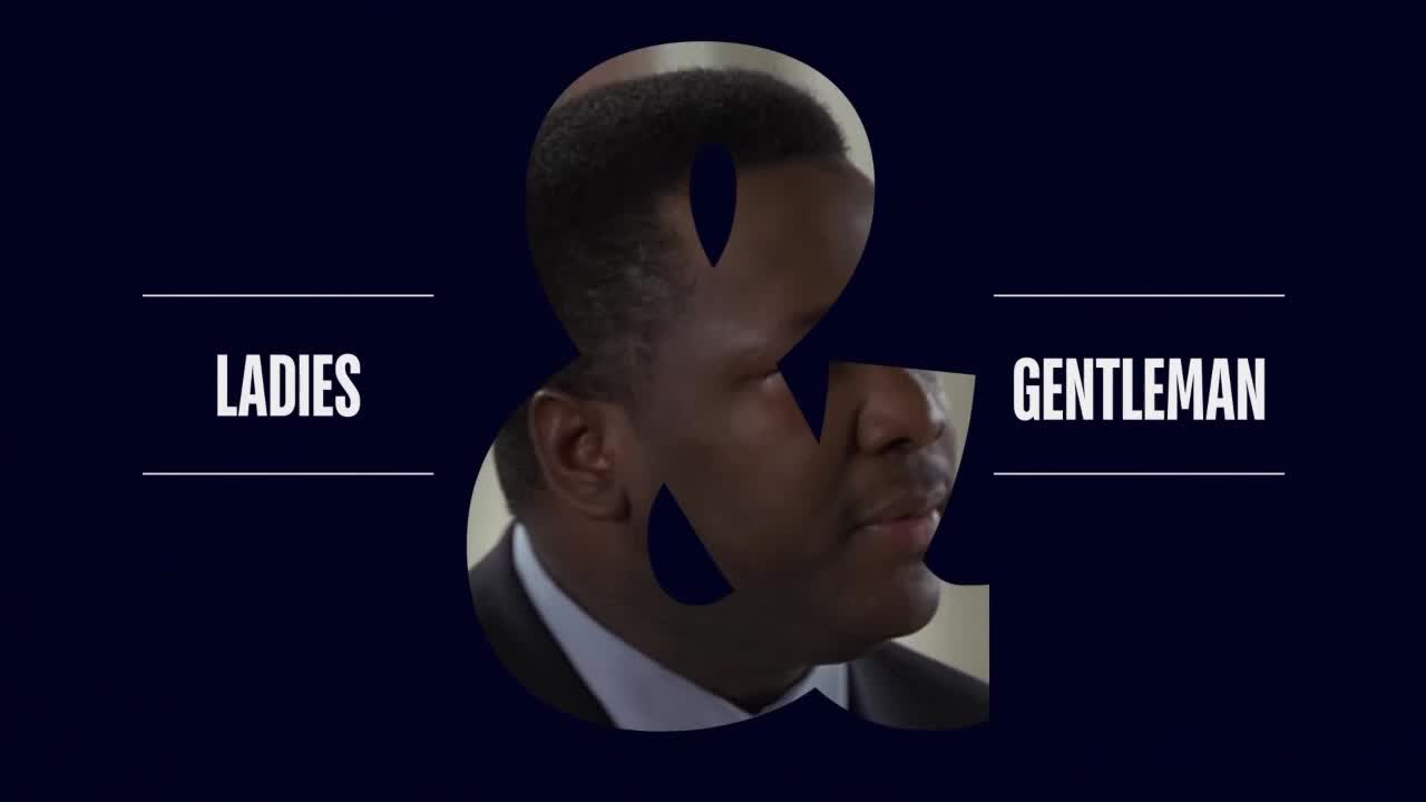 The image shows a man's face partially obscured by an ampersand symbol. "Ladies & Gentleman" is written on either side of the symbol.

