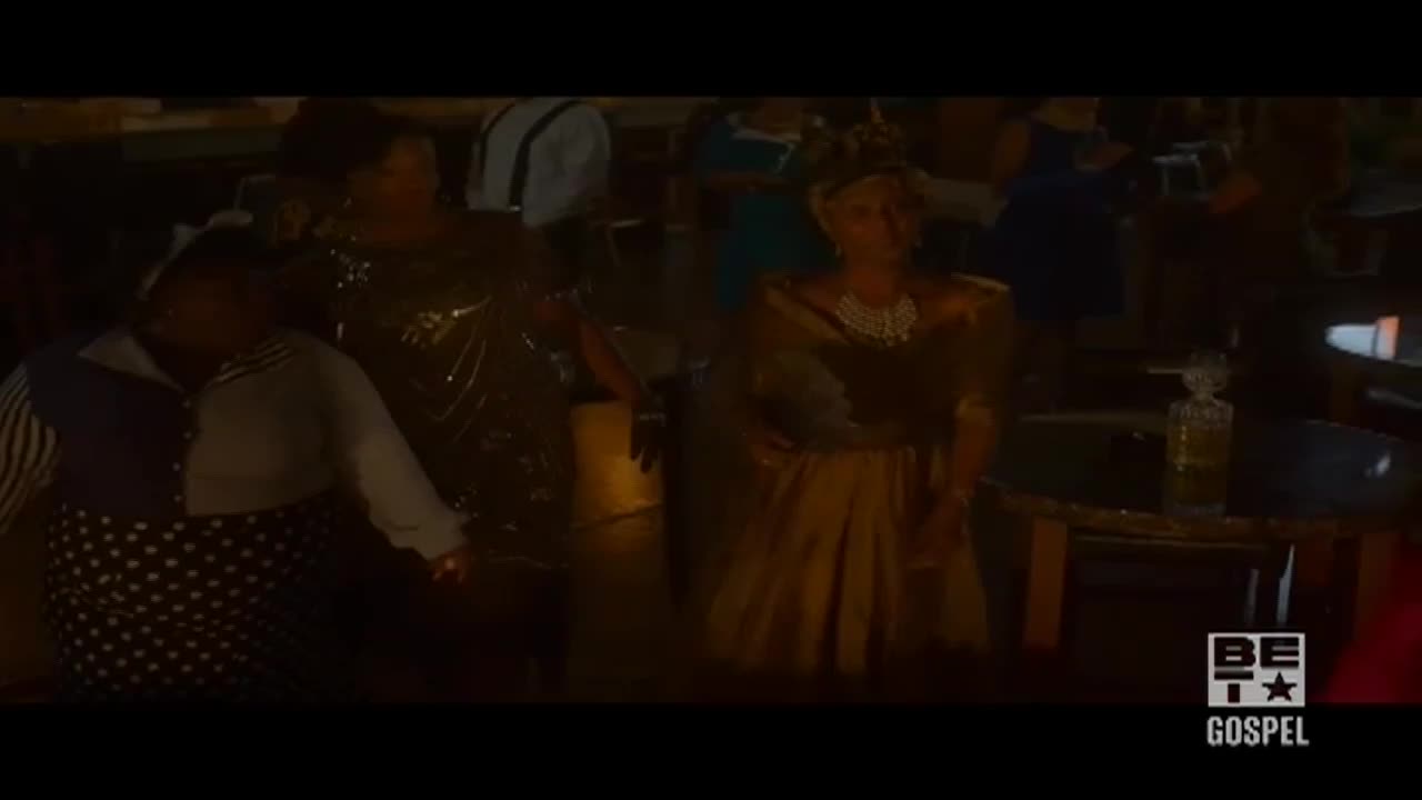 A woman in a gold dress and pearls stands near a table, while others are dancing in the dim light. The BET Gospel logo is in the corner.

