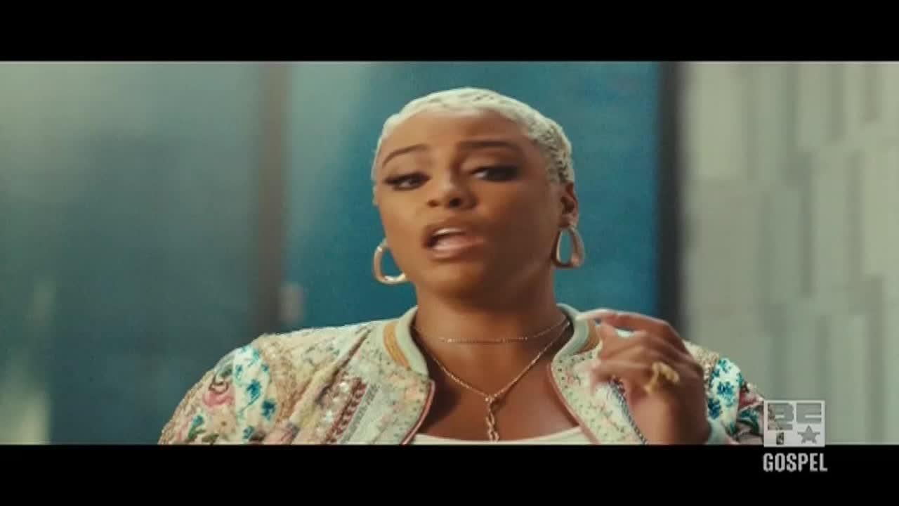The woman with the short, blonde hair is singing, her mouth open, and her hand gesturing. She's wearing a patterned jacket and gold jewelry, and the BET Gospel logo is visible in the corner.
