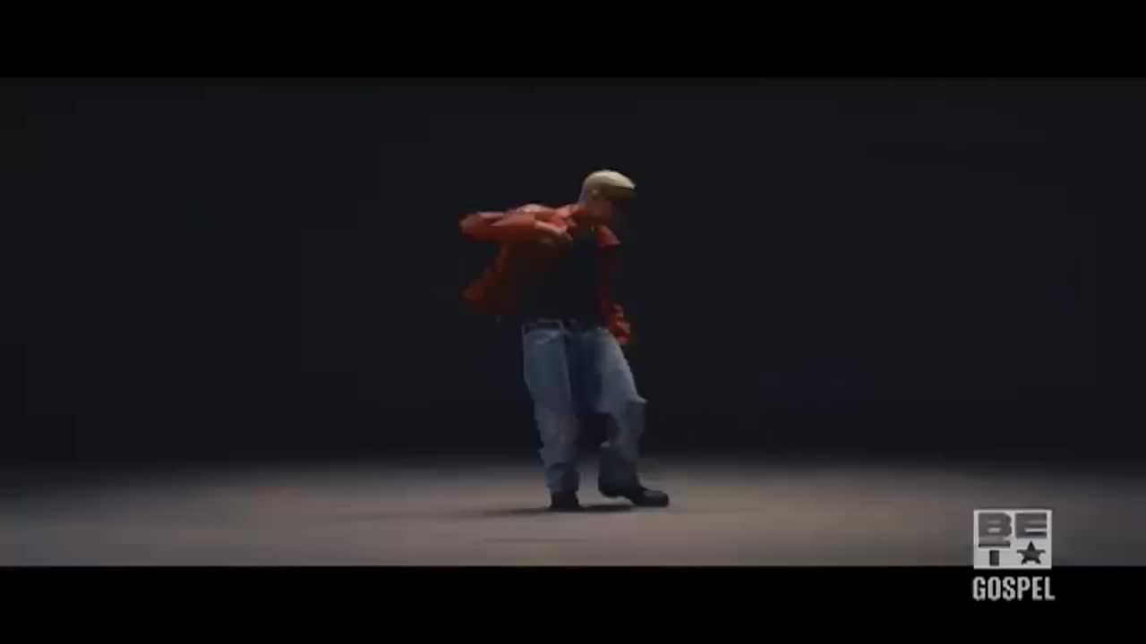 A man in a red jacket and jeans is dancing, his body twisting and turning. The BET Gospel logo is in the corner, and the lighting is dim, focusing on the dancer.
