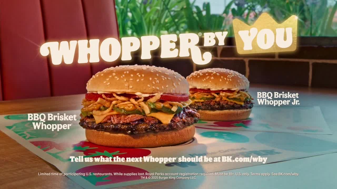 Two fully-loaded burgers, the BBQ Brisket Whopper and its smaller counterpart, sit on a patterned paper. The words "Whopper By You" glow above them, inviting viewers to suggest the next creation.
