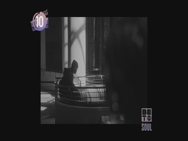 A person in a dark hoodie sits on a curved balcony, looking down. The scene is lit by a bright window, and the BET Soul logo is visible in the corner.
