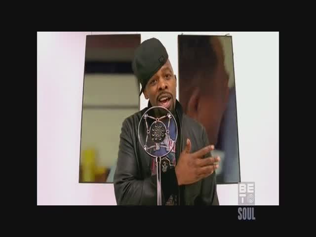 A man in a leather jacket stands before a microphone, gesturing with his right hand. The BET Soul logo is in the corner.
