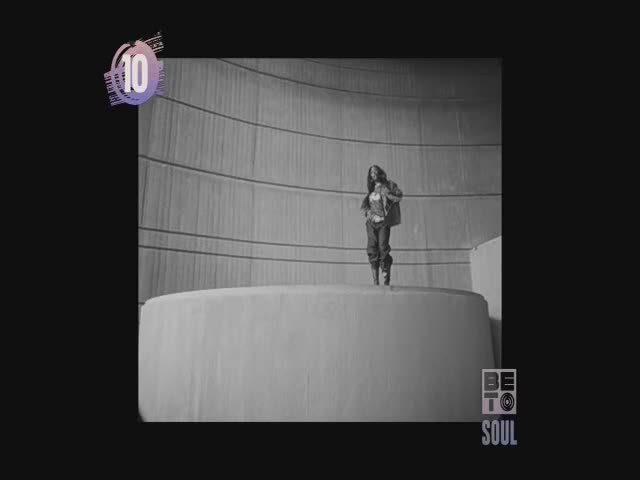 A performer stands on a circular platform, a figure against the backdrop of a curved wall. The BET Soul logo is visible, and the number ten hovers in the corner.
